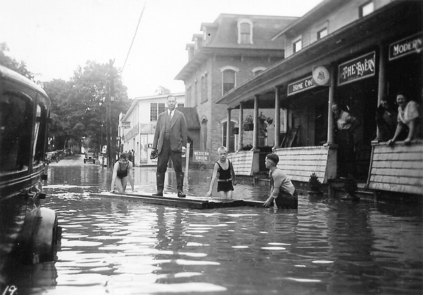 Reprinted from <a data-cke-saved-href='/Products/9780738565064' href='/Products/9780738565064'>Groton</a> by Rosemarie Palmer Tucker, courtesy of the Groton Town Historian archives (pg. 28, Arcadia Publishing, 2009). In this 1935 photo, residents of Groton, New York stand in a flooded Main Street, which was frequently inundated with water by the nearby Owasco Inlet.
