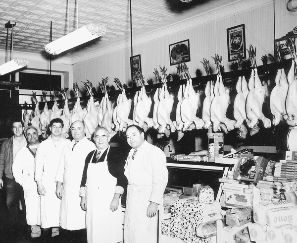 Thanksgiving turkeys hang in a small-town butcher shop.
