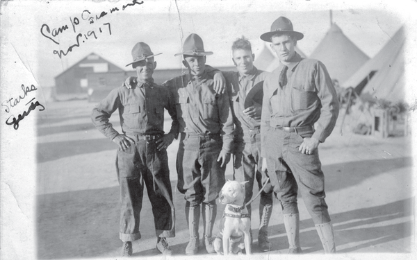 Four soldiers stand with their adopted dog in 1917.