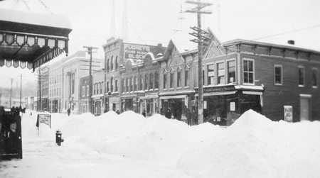 Another New York snowstorm blanketed Sidney, New York. Here, snow piles are pushed in an attempt to clear the sidewalk.
